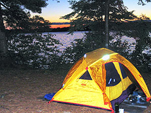 Tent by a lake at sunset